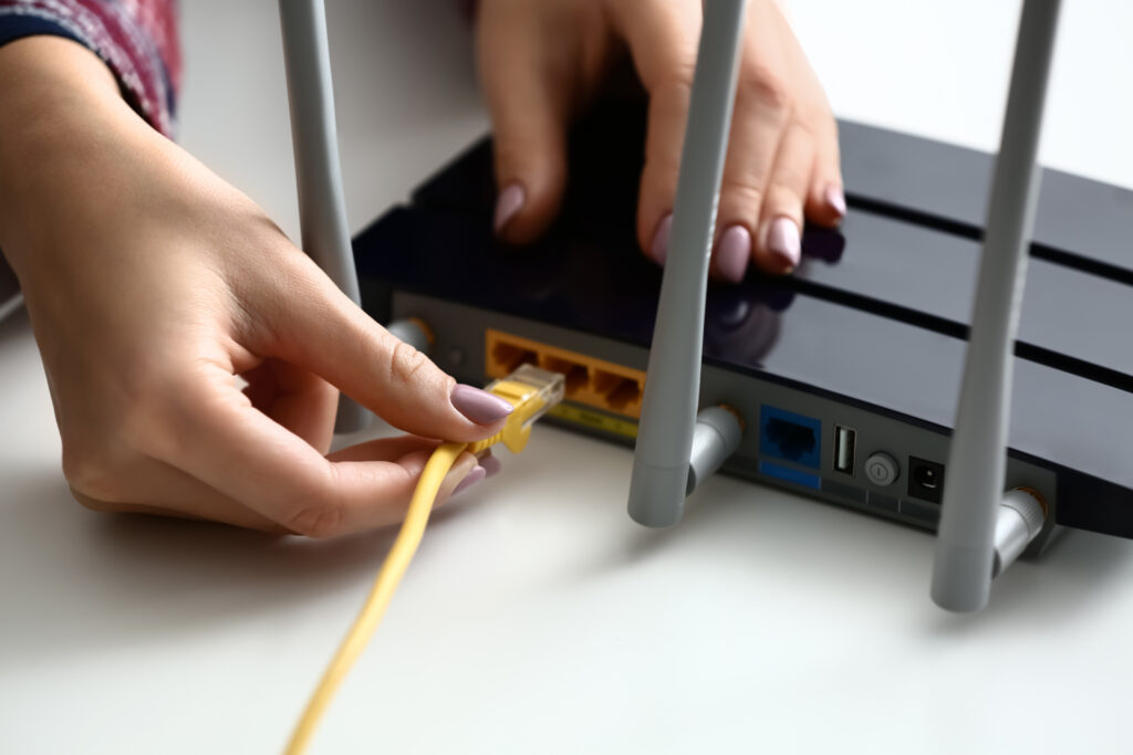 ethernet cable being plugged into Wi-Fi router 